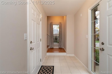 Hall with light tile patterned flooring and baseboards