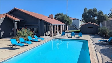Community pool featuring a patio area, a storage shed, and stairs