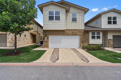 View of front of property featuring stone siding, a garage, board and batten siding, driveway, and a front lawn