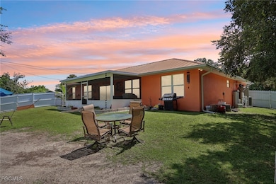 Back of house with a sunroom, a metal roof, a fenced backyard, and stucco siding