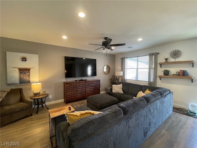 Living area with a ceiling fan, wood finished floo
