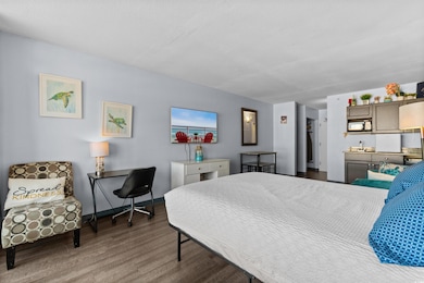Bedroom with dark wood-style flooring and baseboards