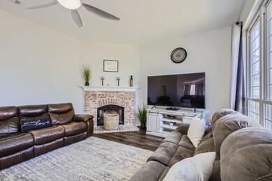 Living room with a brick fireplace, dark hardwood 