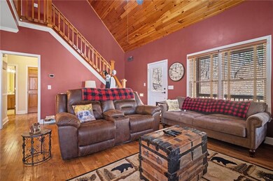 Living room with baseboards, high vaulted ceiling,