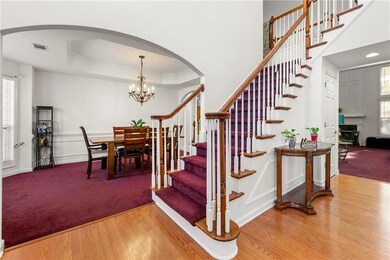 Stairs featuring an inviting chandelier, visible v