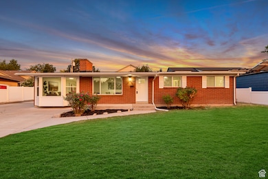 Single story home with brick siding, a chimney, and driveway