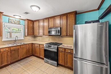 The spacious kitchen with oak cabinets, undercabinet lighting, granite countertops & a suite of stainless steel appliances including a gas range.