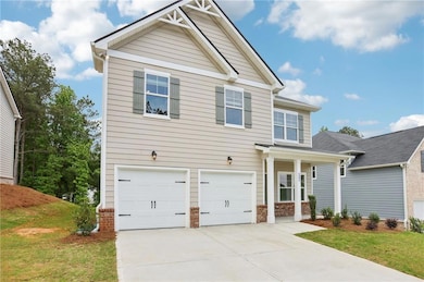 Craftsman-style home featuring an attached garage, driveway, and a front lawn