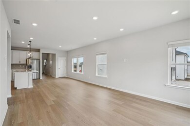 Unfurnished living room featuring sink and light w