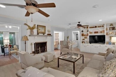 Living room with ceiling fan and light wood-style 