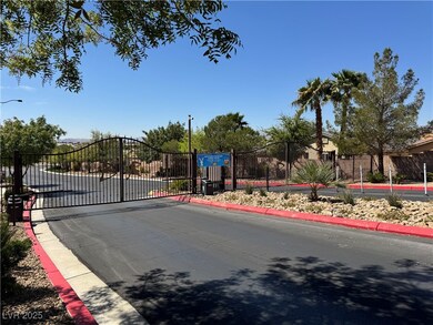 View of street with a gated entry, curbs, and a ga