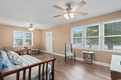 Bedroom with ceiling fan, multiple windows, and ha
