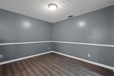 Empty room featuring wood finished floors and a textured ceiling