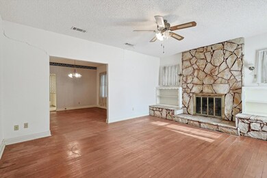 Unfurnished living room with a stone fireplace, wo