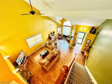 Living room featuring wood-type flooring, high vaulted ceiling, and ceiling fan