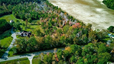 Aerial view of property and surrounding area with a forest