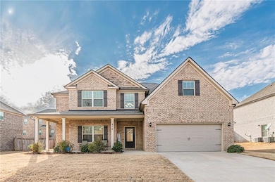 Craftsman house featuring a garage, driveway, brick siding, and covered porch