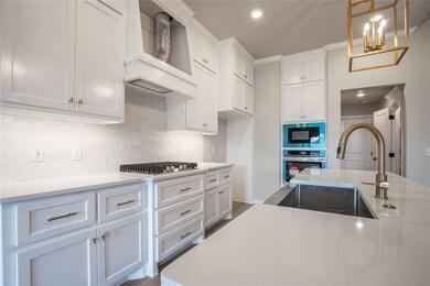 Kitchen featuring wall chimney range hood, sink, w