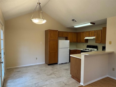 Kitchen featuring freestanding refrigerator, rang