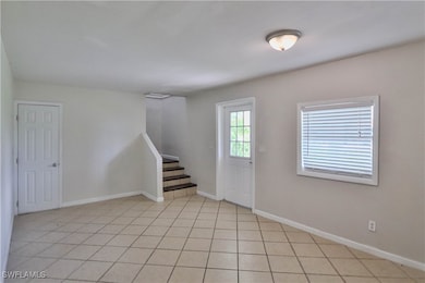 Foyer entrance featuring stairs, baseboards, and l