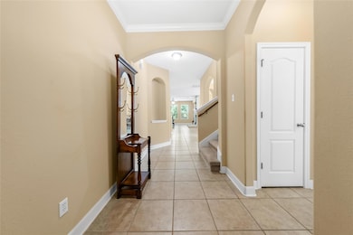 Corridor with light tile patterned flooring, arch
