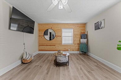 Unfurnished room featuring ceiling fan, wood walls