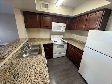 Kitchen with white appliances, dark wood finished