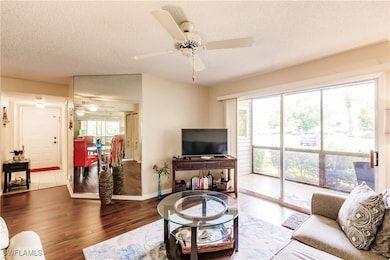 Living room with ceiling fan, a textured ceiling,
