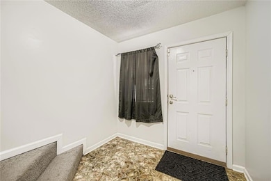 Entryway with a textured ceiling and stone finish flooring