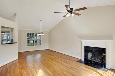 Unfurnished living room with wood finished floors, a ceiling fan, a chandelier, crown molding, and baseboards