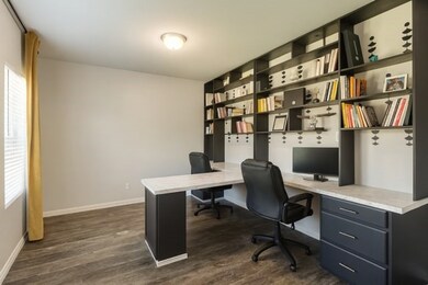 Office featuring dark wood-style flooring and baseboards