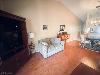 Living room with high vaulted ceiling, baseboards,