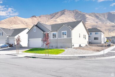 View of front of home featuring a mountain view, board and batten siding, a garage, concrete driveway, and a front yard
