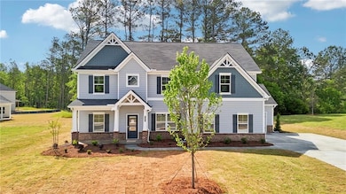 Craftsman house with brick siding, a front yard, and driveway