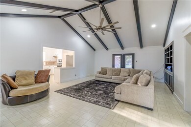Living area featuring beam ceiling, high vaulted ceiling, recessed lighting, french doors, and a ceiling fan