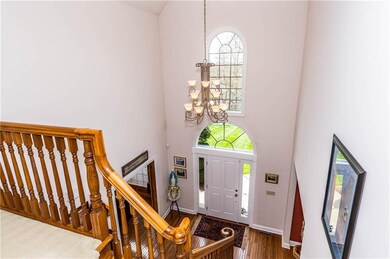 TWO STORY FOYER SHOWCASING HARDWOOD FLOORS AND CUS