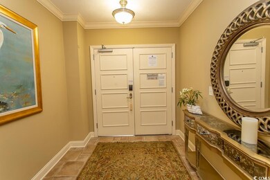 Tiled foyer featuring a textured ceiling and crown