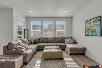 Living area with light wood-style flooring and a textured ceiling