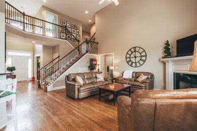 The living room boasts high ceilings, wood floors, and a beautiful staircase.