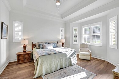 Primary Bedroom featuring a tray  ceiling, luxury vinyl  flooring and   Crown molding.