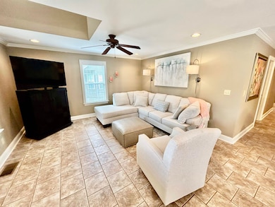 Living room with baseboards, a ceiling fan, ornamental molding, and recessed lighting