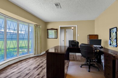 Office with wood-type flooring and a textured ceiling