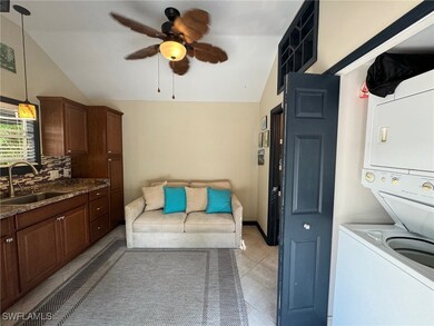 Laundry room featuring ceiling fan, stacked washer
