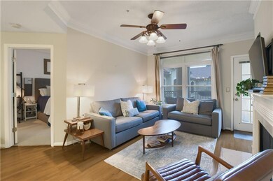 Living area with wood finishes, ornamental molding, a fireplace, and ceiling fan