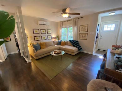 Living area with dark wood-type flooring, a ceili