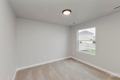 Spare room featuring light colored carpet and baseboards