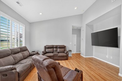 Living area featuring vaulted ceiling, light wood-type flooring, and recessed lighting