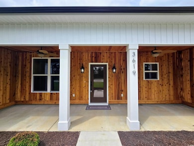 View of exterior entry with ceiling fan and covered porch