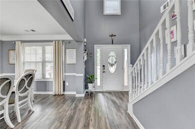 Entrance foyer with wood finished floors, a towering ceiling, plenty of natural light, stairway, and crown molding