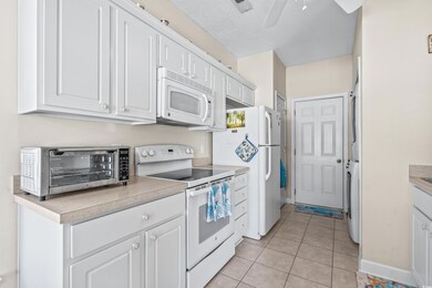 Kitchen featuring a textured ceiling, white cabine